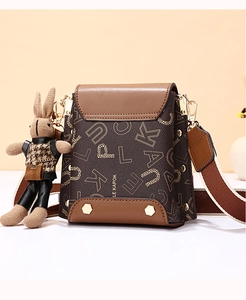 Detail of retro leather crossbody bag with letter print and cute bunny plush pendant