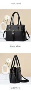 Detail view of black lychee leather handbag featuring gold hardware and stylish tassels