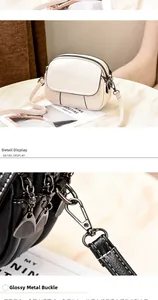 Macro view of glossy metal hardware clips and lychee textured faux leather crossbody bag