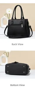 Detail view showing the back zipper pocket and gold protective feet of the black tote bag