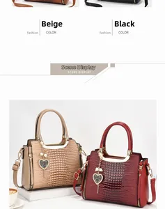 Detail of crocodile embossed handbag with heart charm and detachable shoulder strap