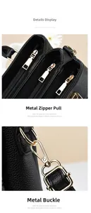 Detail view of golden metal zipper and swivel snap hook on black litchi grain leather bag