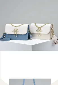 Detail of crossbody bag with quilted leather texture and golden swan pearl clasp