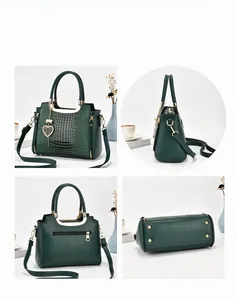 Detail shots of green crocodile embossed handbag with heart charm and protective base studs