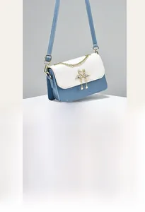 Close-up of heart quilted mini bag with golden double swan hardware and pearl chain detail