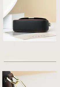 Close-up of contrast leather stitching and golden metal buckle on a black crossbody bag
