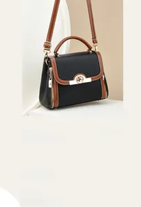 Close-up of contrast crossbody bag featuring golden twist lock and textured leather