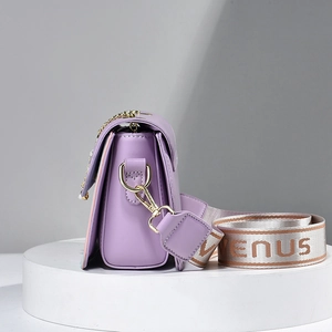 Light purple small crossbody bag with a wide woven Venus strap on a white display stand