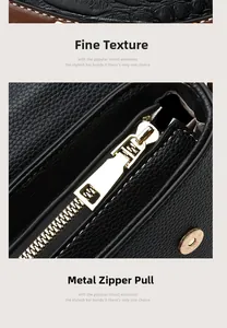 Detailed macro view of black lychee grain leather texture and premium gold zipper hardware