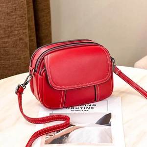 Red pebbled leather crossbody bag with white contrast stitching and double zippers