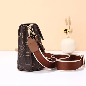 Chic brown monogram crossbody bag with wide shoulder strap and golden hardware accents