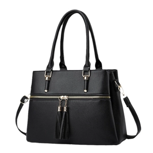 Large black pebbled leather tote bag with gold hardware and stylish double tassels