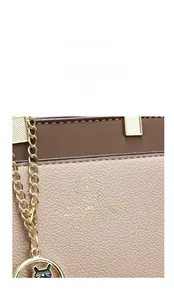 Macro detail of lychee texture leather with gold hardware and cat-shaped pendant charm