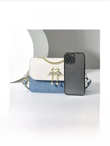 Detail der Mini-Tasche mit Herzprägung, Schwanenschnalle und Perlenanhänger-Akzent