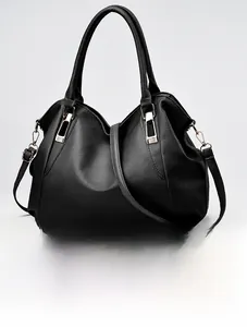 Close-up of black lychee-grain leather handbag with elegant gold hardware buckles