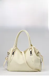 Close-up of beige textured leather tote bag showing side buckle and gold hardware detail