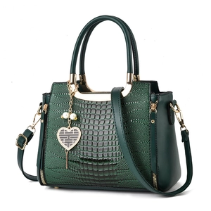 Fashionable dark green faux crocodile embossed handbag with gold hardware and heart charm