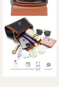 Internal storage capacity of a black and caramel leather crossbody bag with gold lock