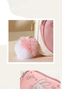 Detail of pink and white bag featuring cute rabbit embroidery and pearl pompom charm