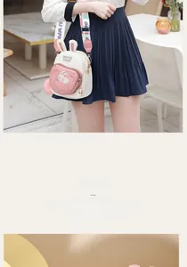 Detail of bunny ear crossbody bag with cute embroidery and pink pompom accessory