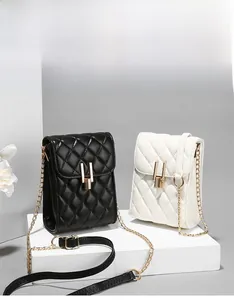 Close-up of quilted pattern and gold chain on black and white mini phone bags