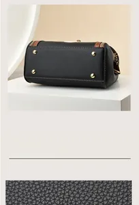 Detail view of black lychee grain leather crossbody bag with golden bottom protective rivets