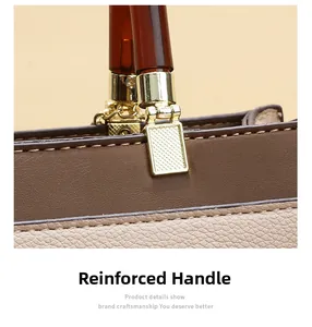 Detail of reinforced amber resin handle with gold hardware on contrast leather handbag