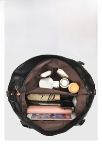 Macro view of spacious black leather tote bag interior with multiple compartments and pockets
