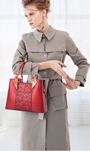 Detail der roten Ledertasche mit Blumenstickerei und Seidenschal am Griff