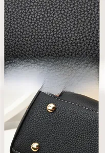 Detail showing black lychee grain leather texture with precise stitching and gold studs