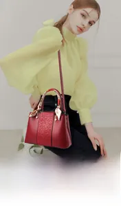 Detail of red wedding handbag with silk scarf handle and pearl charm pendant