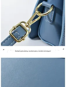 Detailaufnahme der hellblauen Ledertasche mit Metallschnallen und feiner Lederkörnung