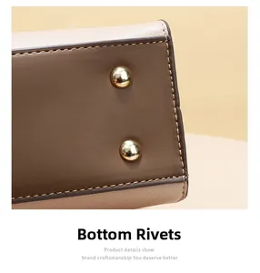 Macro shot of pebbled leather bag bottom with golden metal feet and contrast stitching