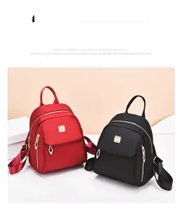 Vue détaillée de sacs à dos élégants rouge foncé et noirs avec garnitures métalliques