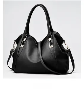 Close-up of black lychee leather texture and golden metal buckle on women handbag