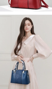 Close-up of elegant wedding handbag with floral embossing, silk scarf and pearl charm