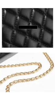 Detail of premium black quilted leather texture and polished light gold metal chain strap