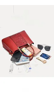 Draufsicht auf rote Handtasche mit Blumenprägung und großem Fassungsvermögen für Utensilien