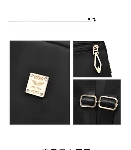 Détails du matériel doré poli et plaque logo sur le sac à dos en nylon noir