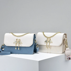 Women heart-quilted crossbody bag with swan buckle and wide strap on display stand