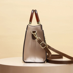 Taupe pebbled leather handbag with dark resin handles and adjustable shoulder strap