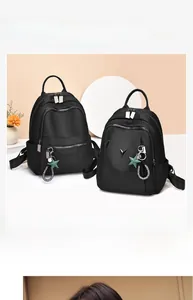 Detail view of black waterproof nylon backpack with silver zippers and star charm