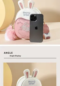 Detail view of mini rabbit crossbody bag with bunny ears next to a smartphone