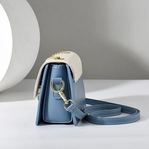 Elegante Umhängetasche in Navy und Beige mit Goldkette und gefalteter Seitenansicht