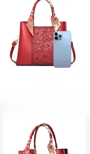 Detail einer roten Handtasche mit Blumenprägung Seidenschal-Griff und Trageriemen