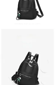 Detail of waterproof black backpack showing silver zippers and star charm accessory