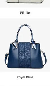 Detail of luxury handbag featuring silk scarf handle, pearl charm and moire embossed panel