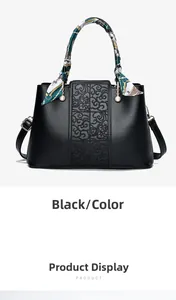 Detail of black faux leather handbag with textured patterns and silk scarf handle decor