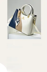 Détail mini sac à main avec surpiqûres tricolores, logo doré et pendentif papillon