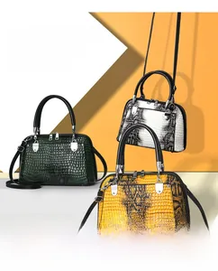 Detailed view of fashion handbags featuring crocodile and snake patterns with silver hardware